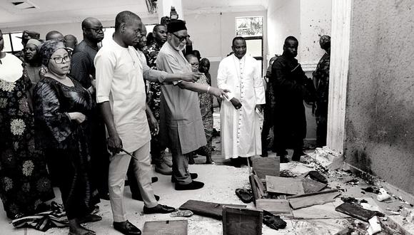 El gobernador del estado de Ondo, Rotimi Akeredolu (3.° a la izquierda), señala sangre en el piso manchado después de un ataque de hombres armados en la iglesia católica St. Francis en la ciudad de Owo, en el suroeste de Nigeria, el 5 de junio de 2022. (Foto: AFP)