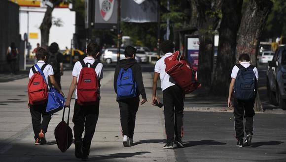 Niños caminan después de salir de la escuela. (Foto referencial: Eitan ABRAMOVICH / AFP)