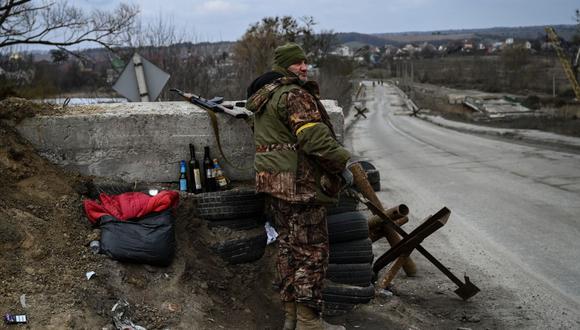 An Ukrainian serviceman stands guard at a checkpoint next to the last bridge on the road that connects Stoyanka with Kyiv, on March 6, 2022. (Photo by ARIS MESSINIS / AFP)