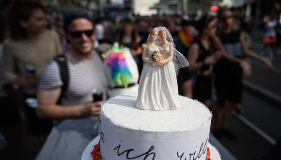 Esta foto muestra un pastel de bodas en el que miembros de la comunidad  LGBTIQ participan en el Orgullo de Zurich antes de una votación nacional sobre el matrimonio homosexual. (Foto: Fabrice COFFRINI / AFP)