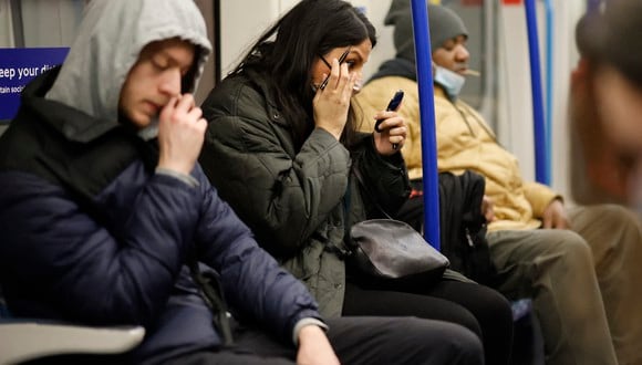 Los viajeros con y sin mascarillas viajan en un tren subterráneo de Transport for London (TfL) en Londres. (Foto: Tolga Akmen / AFP)