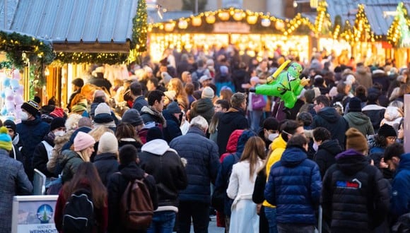 La gente visita el mercado navideño clásico de Viena "Christkindlmarkt" en la plaza frente al Ayuntamiento de Viena, Austria, el 12 de noviembre de 2021, en pleno rebrote del coronavirus. (GEORG HOCHMUTH / APA / AFP).