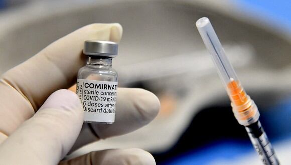 Un trabajador médico sostiene una jeringa y un vial de la vacuna Comirnaty de Pfizer-BioNTech contra Covid-19. (Foto: Tiziana FABI / AFP)
