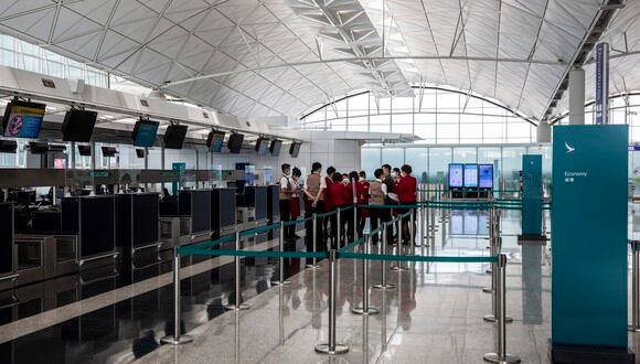 Los miembros del personal de Cathay Pacific se reúnen en los mostradores de facturación en el Aeropuerto Internacional de Hong Kong el 11 de agosto de 2021.
 (Foto: ISAAC LAWRENCE / AFP)