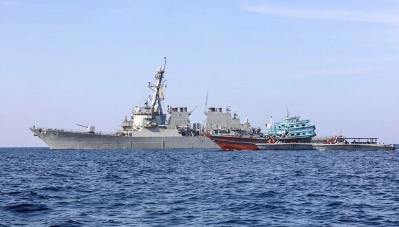 El destructor de misiles guiados USS Cole (DDG 67) transfiriendo el control de un barco pesquero apátrida a la Guardia Costera de Yemen en el Golfo de Omán. (Foto: BANDAR AL-JALOUD / various sources / AFP)