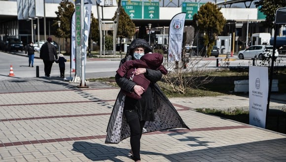 Una refugiada ucraniana sostiene a su hijo después de su llegada en autobús al puesto fronterizo entre Grecia y Bulgaria en Promachonas, en el norte de Grecia, el 11 de marzo de 2022. (Foto: Sakis MITROLIDIS / AFP)