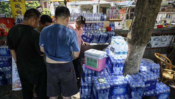 La gente compra agua y helado durante el clima cálido en la isla de Gulangyu en Xiamen, en la provincia de Fujian, en el sur de China, el 24 de julio de 2022. (Foto de Jade Gao / AFP)