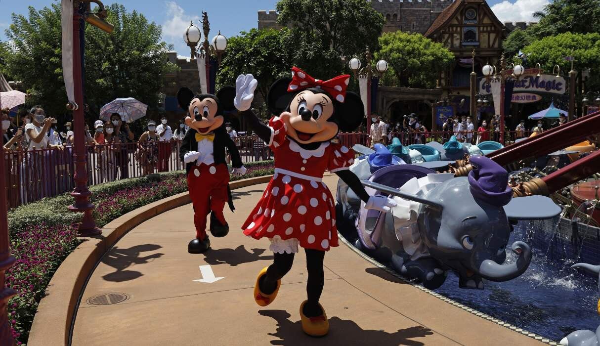 Los icónicos personajes de dibujos animados Minnie y Mickey Mouse saludan a los visitantes en Disneyland Hong Kong. (AP/Kin Cheung).