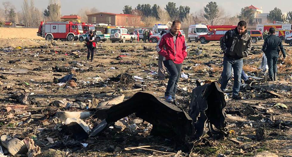 Las personas caminan cerca de los restos del avión ucraniano que se estrelló cerca del aeropuerto Imam Khomeini en Teherán. (Foto: AFP)