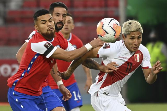 Chile's Paulo Diaz (L) and Peru's Raul Ruidiaz vie for the ball during their closed-door 2022 FIFA World Cup South American qualifier football match at the National Stadium in Santiago, on November 13, 2020. (Photo by Martin BERNETTI / POOL / AFP)