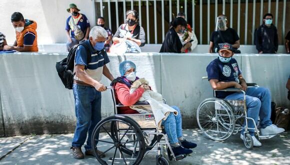 Una paciente recuperada del coronavirus COVID-19, se va en una silla de ruedas empujada por su esposo después de ser dada de alta del Hospital General Venados, en la Ciudad de México. (Foto: AFP/PEDRO PARDO)