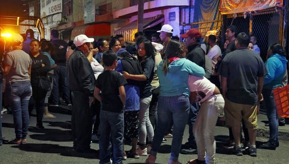 Familiares y amigos reaccionan afuera del bar donde 12 personas fueron asesinadas por un grupo armado que abrió fuego contra los clientes y el personal, en Irapuato, estado de Guanajuato, México, el 15 de octubre de 2022. (Foto de Mario ARMAS / AFP)