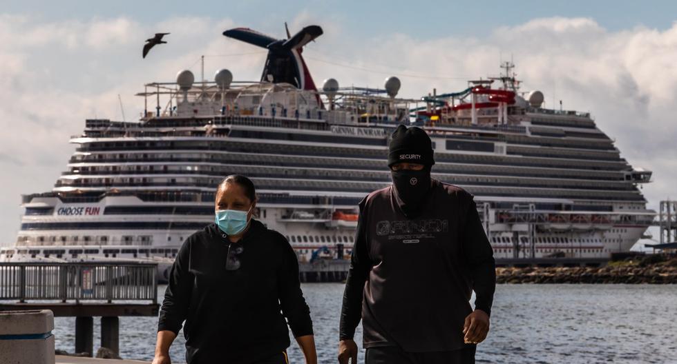 Una mujer que usa una mascarilla corre con los cruceros atracados en el fondo debido a una orden de no navegar en el puerto de Long Beach, California (Estados Unidos). (Apu GOMES / AFP)