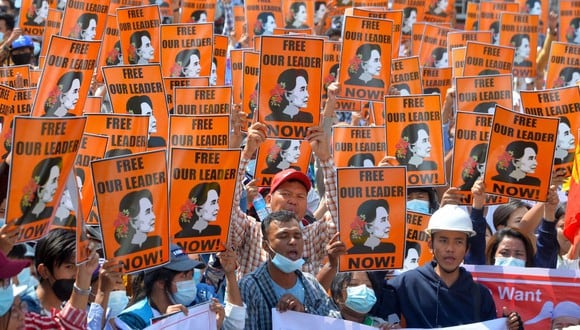 Los manifestantes sostienen carteles con la imagen de la líder civil detenida Aung San Suu Kyi durante una manifestación contra el golpe militar en Naypyidaw, el 28 de febrero de 2021. (STR / AFP)
