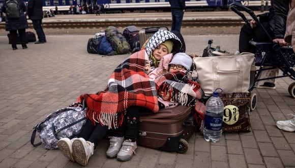 Los niños se acuestan sobre los equipajes mientras las familias esperan para abordar un tren en la estación central de Kramatorsk mientras huyen de la ciudad oriental de Kramatorsk, en la región de Donbass, el 5 de abril de 2022. (Foto de FADEL SENNA / AFP)