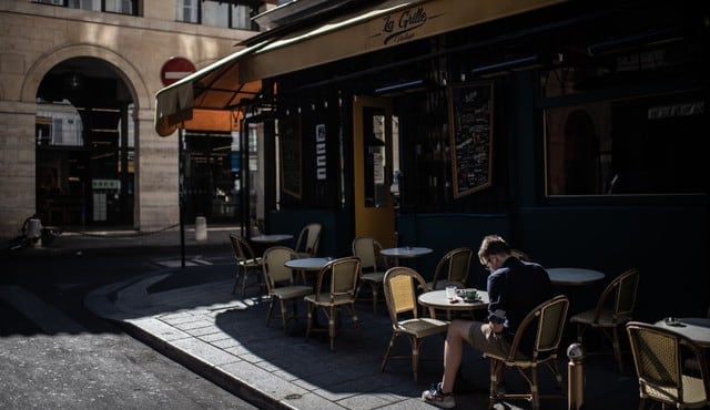 Un hombre es visto este martes sentado en la terraza de una cafetería en París (Francia). (Martín BUREAU / AFP).