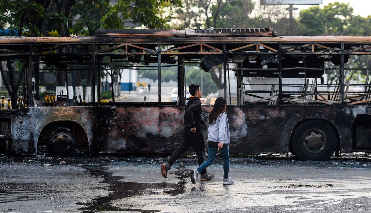 No obstante, los ciudadanos observaban asombrados un bus incinerado luego de las manifestaciones y enfrentamientos que se registraron el martes. (Foto: AFP)