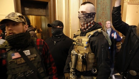 Los manifestantes intentan ingresar a la Cámara de Representantes de Michigan y la Policía Estatal de Michigan los mantiene fuera. (Foto: AFP/Jeff Kowalsky)