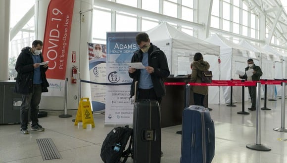 Los viajeros miran los resultados de COVID-19 después de ser evaluados dentro del aeropuerto internacional JFK en Nueva York (Estados Unidos), el 22 de diciembre de 2020. (Kena Betancur / AFP).