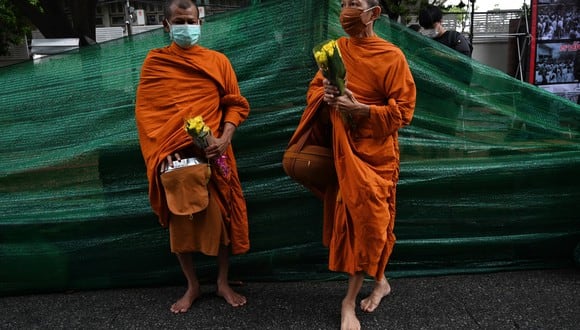 Los monjes budistas reciben limosnas en Bangkok el 6 de octubre de 2021. (Foto de Lillian SUWANRUMPHA / AFP)