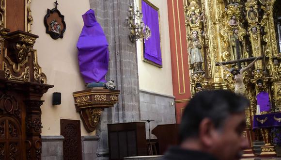 Las imágenes de la virgen María y de santas de una parroquia de la Ciudad de México fueron cubiertas con mantas moradas con la intención de llamar la atención sobre la violencia que sufren la mujeres. (AFP).