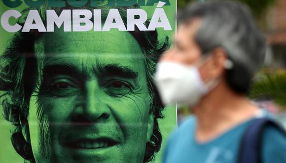 Una persona se para frente a una pancarta que representa al candidato presidencial colombiano por la Coalición Centro Esperanza, Sergio Fajardo, durante un mitin de campaña, en Cali, Colombia, el 18 de mayo de 2022. (Foto de Paola MAFLA/AFP)