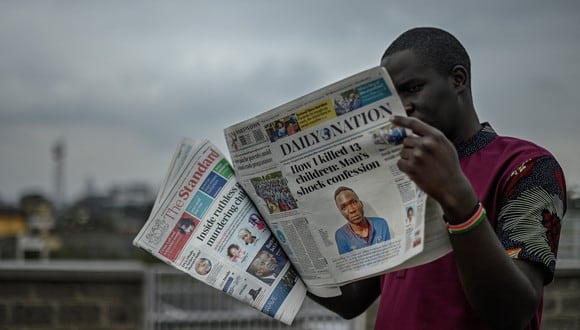 Un hombre sostiene los periódicos The Standard y Daily Nation que llevan titulares sobre el asesino Masten Milimo Wanjala, involucrado en la muerte de al menos 10 niños en Nairobi el 15 de julio de 2021.  (Foto: SIMON MAINA / AFP)