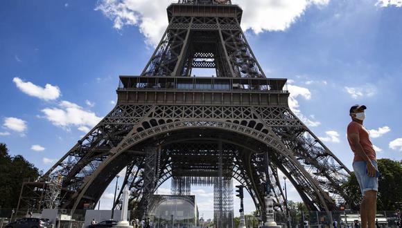 Un hombre con una máscara protectora camina cerca de la Torre Eiffel, en París, Francia, el 27 de agosto de 2020. (EFE/EPA/IAN LANGSDON).