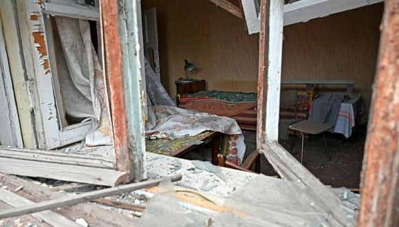 Esta fotografía muestra una habitación dañada a través de ventanas rotas después de que un misil impactara en un edificio en las afueras de Kharkiv el 12 de abril de 2022. (Foto de SERGEY BOBOK / AFP)