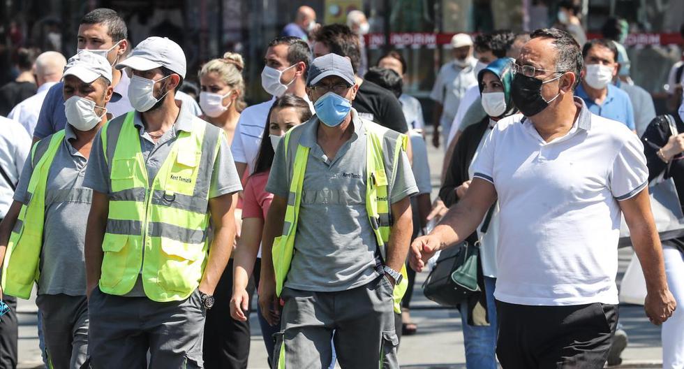 Imagen referencial. Personas con mascarillas por el coronavirus caminan por la calle en Ankara (Turquía). (Adem ALTAN / AFP).