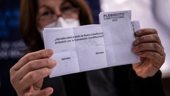 Un trabajador de la municipalidad de Providencia muestra una papeleta en un colegio electoral antes del referéndum del próximo domingo en Santiago el 2 de septiembre de 2022. (Foto por MARTÍN BERNETTI / AFP)