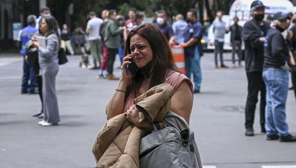 Una mujer habla por teléfono después de un terremoto en la Ciudad de México el 19 de septiembre de 2022. Un terremoto de magnitud 7,4 sacudió el oeste de México, remeciendo edificios en la Ciudad de México. (Foto: RODRIGO ARANGUA / AFP)