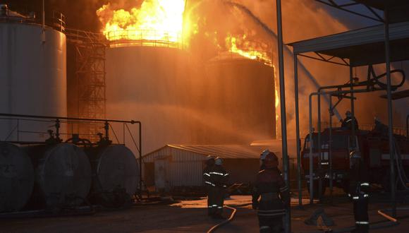 Varios bomberos trabajan en las labores de extinción del incendio declarado en un depósito de combustible cerca de Kiev. (Foto: EFE)
