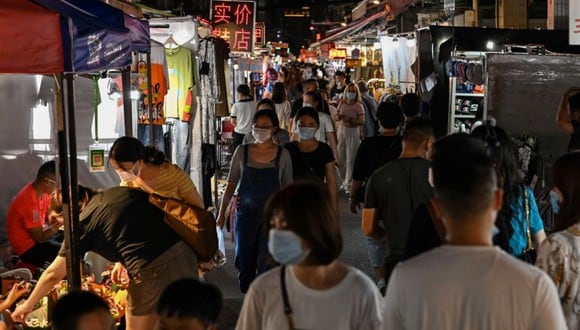 Esta foto tomada el 6 de agosto de 2020 muestra a personas caminando por un mercado nocturno en Wuhan, en la provincia central de Hubei en China. (Foto de Hector RETAMAL / AFP).