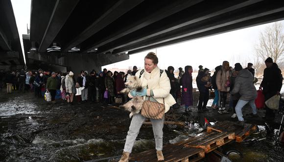 Una mujer lleva a su perro durante la evacuación de civiles de la ciudad de Irpin, al noroeste de Kiev, el 8 de marzo de 2022. (Foto: Sergei SUPINSKY / AFP)