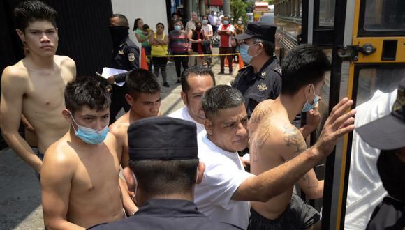 Las personas detenidas por presuntos vínculos con pandillas son escoltadas por la Policía Nacional Civil durante el estado de emergencia declarado por el gobierno salvadoreño en el centro penal de San Salvador el 25 de abril de 2022. (Foto por MARVIN RECINOS / AFP)