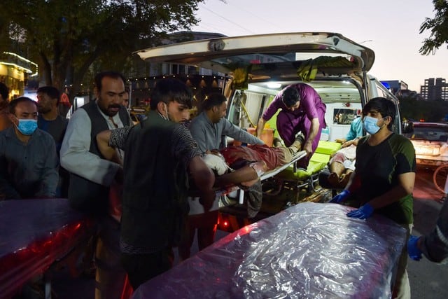 Imagen de voluntarios y personal médico llevando un herido para recibir tratamiento después de dos poderosas explosiones en Kabul, Afganistán. (Wakil KOHSAR / AFP).