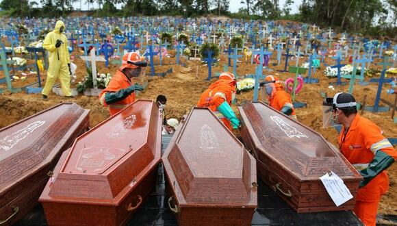 Los ataúdes se descargan para ser enterrados en una fosa común en el cementerio Nossa Senhora en Manaos, estado de Amazonas, Brasil. (Foto: AFP/MICHAEL DANTAS)