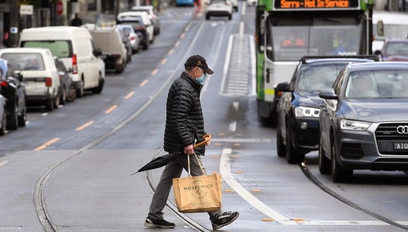 Un hombre cruza una calle en Melbourne el 11 de octubre de 2021, durante un bloqueo contra el coronavirus. (Foto de William WEST / AFP)