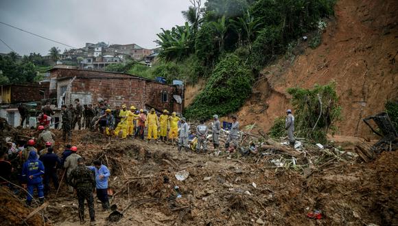 Soldados, bomberos y residentes buscan víctimas un día después de un deslizamiento de tierra en la comunidad Jardim Monte Verde, barrio de Ibura, en Recife, estado de Pernambuco, Brasil, el 29 de mayo de 2022. (Foto de Brenda ALCANTARA / AFP)