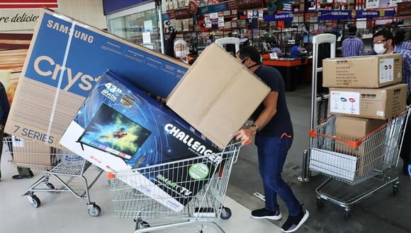 Compradores salen de un centro comercial llevando electrodomésticos este viernes en Bogotá. (EFE/ Carlos Ortega).