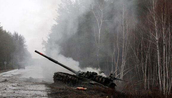 El humo se eleva desde un tanque ruso destruido por las fuerzas ucranianas al costado de una carretera en la región de Lugansk el 26 de febrero de 2022. (Foto de archivo: Anatolii Stepanov / AFP)