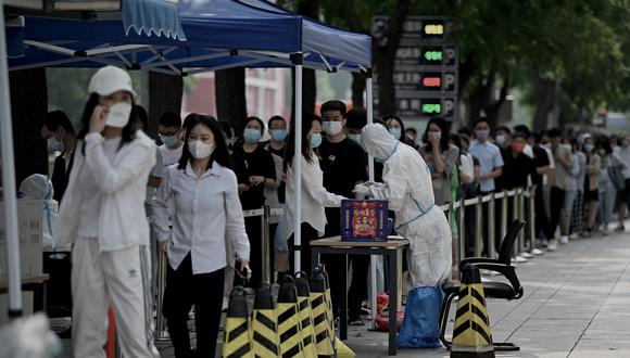 La gente hace cola en un sitio de recolección de hisopos para detectar el coronavirus Covid-19 en Beijing el 13 de junio de 2022. (Foto de Noel Celis / AFP)