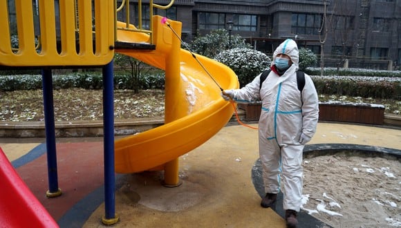 Esta foto muestra a un miembro del personal rociando desinfectante en un área residencial cuando la ciudad comienza a reabrir después de un bloqueo de coronavirus Covid-19 en Xi'an, en la provincia de Shaanxi, en el norte de China. (Foto: AFP)