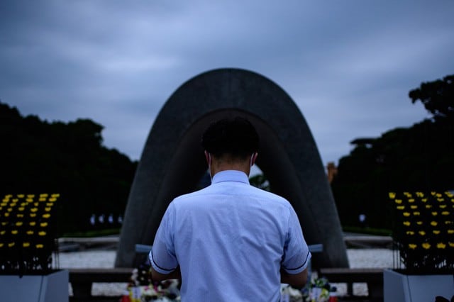 Un visitante ora por las víctimas de la bomba atómica frente al cenotafio, en el Parque Memorial de la Paz de Hiroshima, en Hiroshima.- (Philip FONG / AFP)