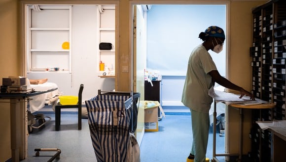 Un miembro del personal médico se encuentra junto a dos habitaciones de un paciente de Covid-19, en la unidad de cuidados intensivos. (Foto: Carla BERNHARDT / AFP)
