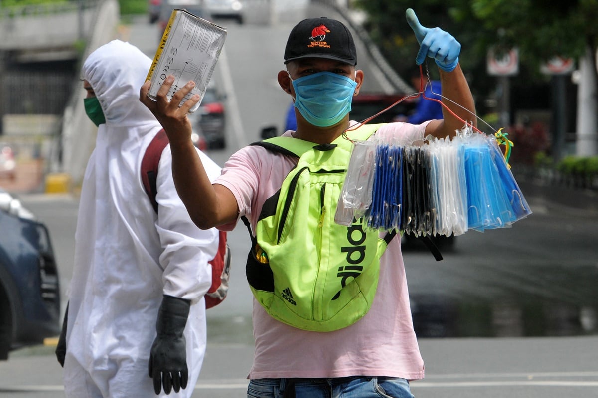 Un hombre vendiendo mascarillas en la calle. Foto de JOSE SANCHEZ LINDAO / AFP