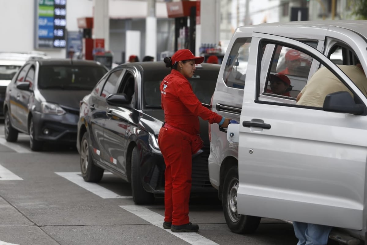 Trabajadora del grifo atiende a conductores que esperan por varios minutos para cargar GLP ante la alta demanda registrada en el establecimiento. (Foto: César Campos/@photo.gec)