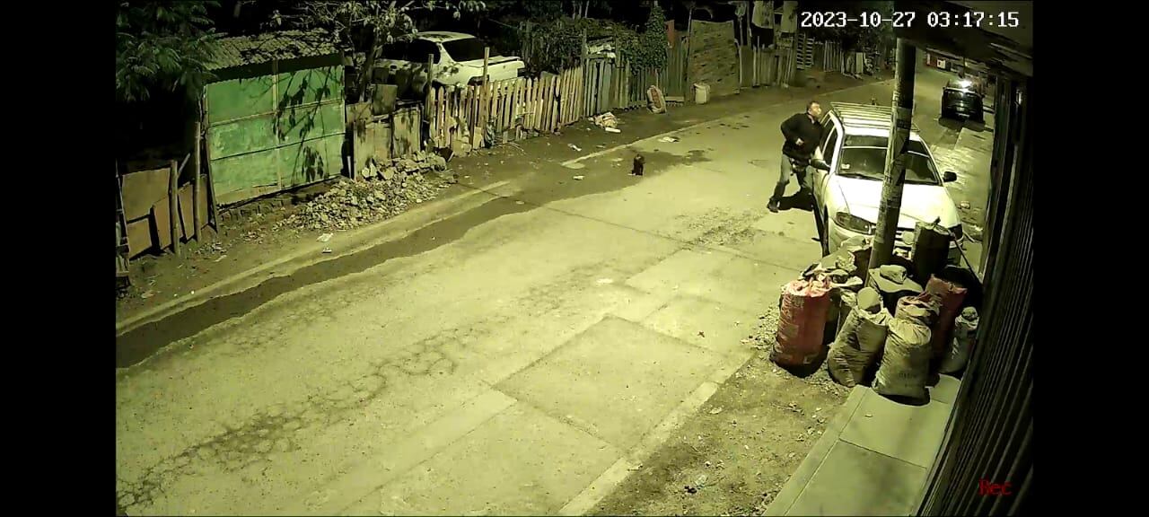 Los hampones se acercan al vehículo de la víctima e intentan forzar la cerradura. Hicieron varios intentos.