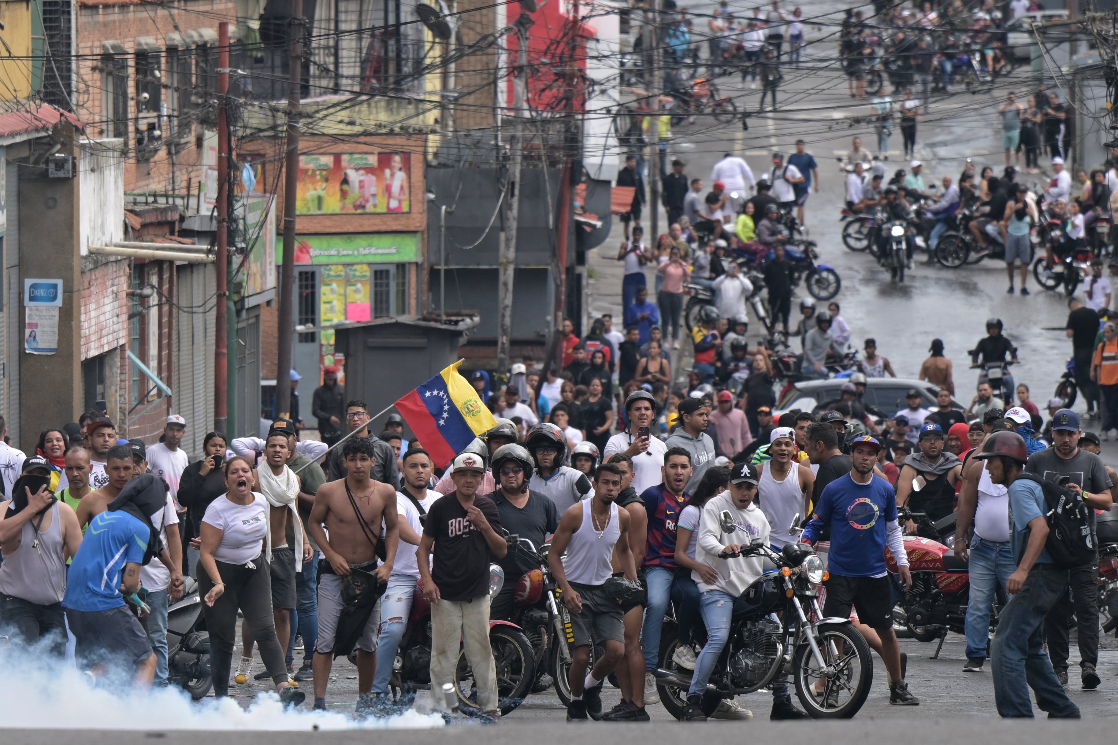Una lata de gas lacrimógeno cae frente a manifestantes durante una protesta contra el gobierno del presidente de Venezuela Nicolás Maduro en Caracas el 29 de julio de 2024. (Foto de Yuri CORTEZ / AFP).